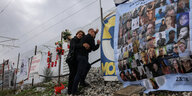 Ein Paar gedenkt am Zaun der Unglückstelle den Opfern des Zugunglücks