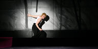 Die Schauspielerin Lina Beckmann erscheint in einem Lichtspot vor einer dunklen Wand