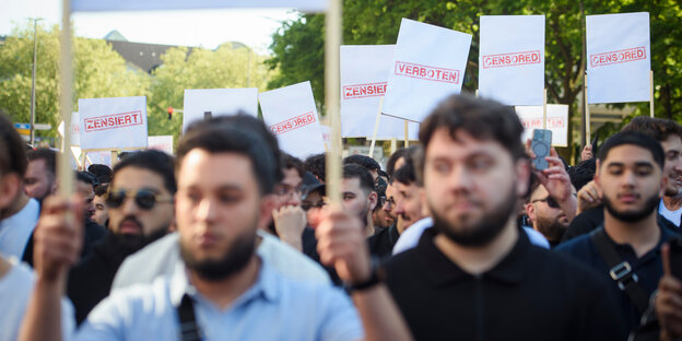 Demonstranten halten Schilder mit den Aufdrucken „Verboten“, „Zensiert“ und „Censored“ auf einer Kundgebung des islamistischen Netzwerks Muslim Interaktiv im Hamburger Stadtteil St. Georg in die Höhe.